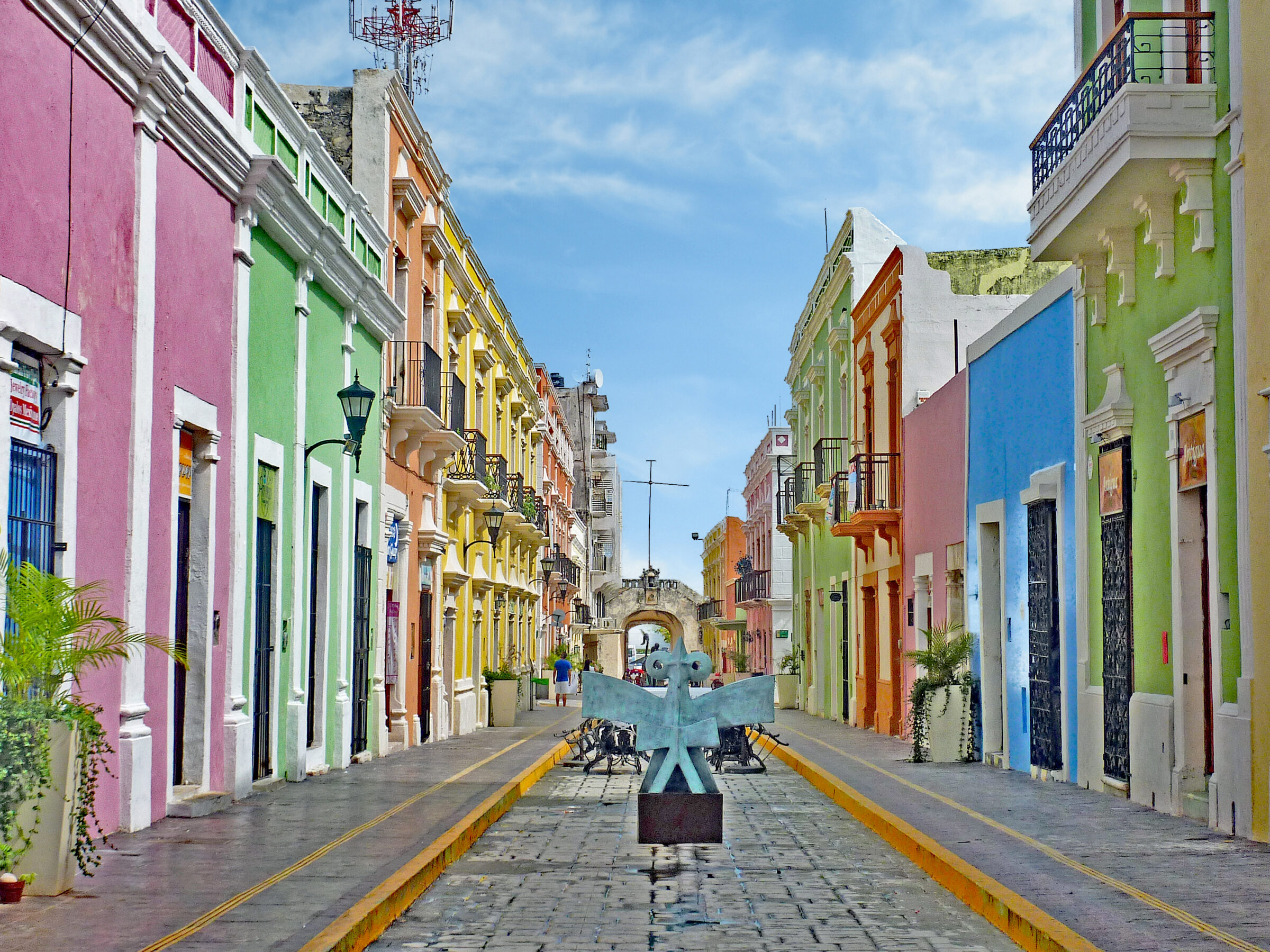 Ruelle colorée dans la ville historique de Campeche, Mexique, avec maisons aux façades vives et pavés anciens.