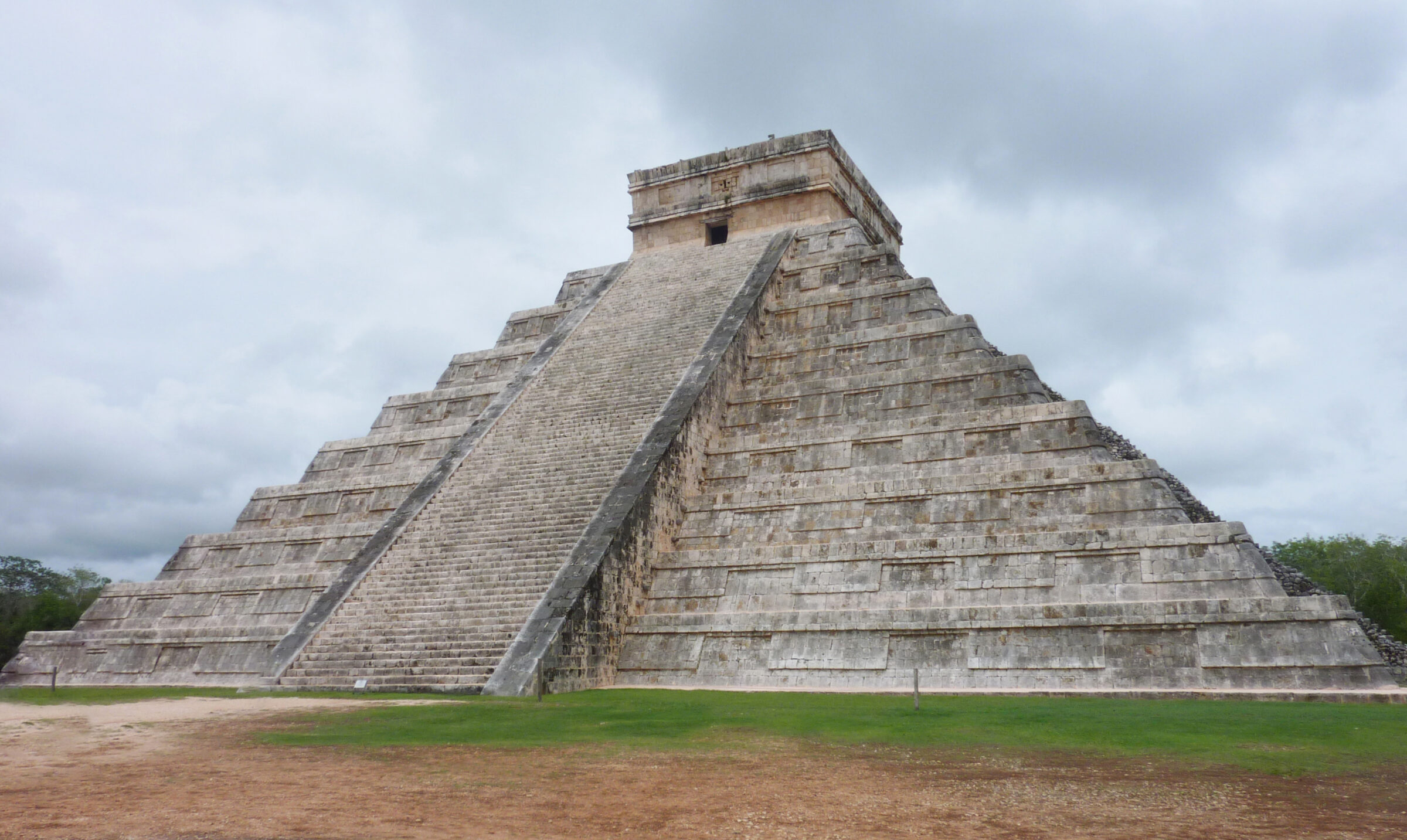 La pyramide de Chichén Itzá sous un ciel nuageux, juste avant une averse, sans aucun visiteur autour.
